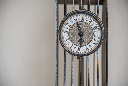 Antique wall clock with hands and Roman numerals, adding a vintage touch to any room.