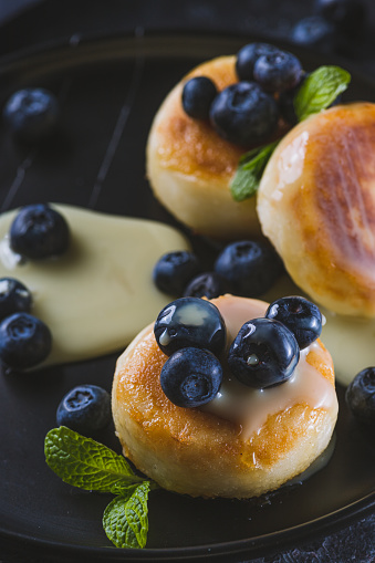 Cheesecakes served with berries and condensed milk