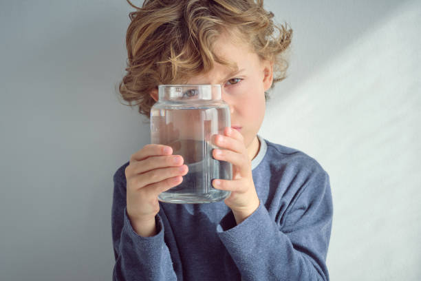 istock Blond haired boy with jar of water 2047081334