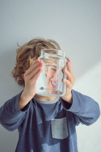 istock Smiling boy with glass jar of water 2047081340
