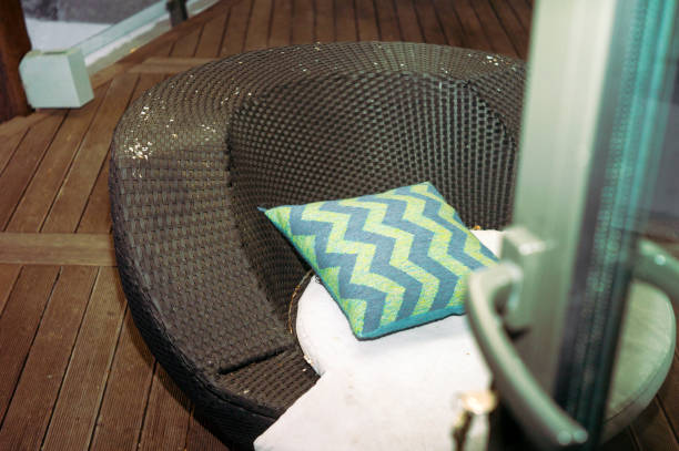 an empty wicker armchair and a pillow, indoor shot