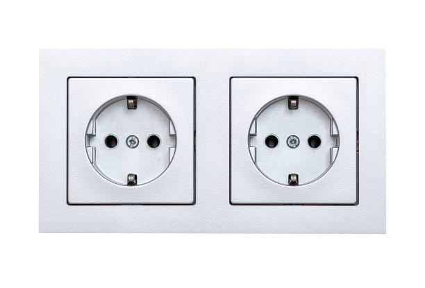 Black power socket mounted on dark gray wall.
