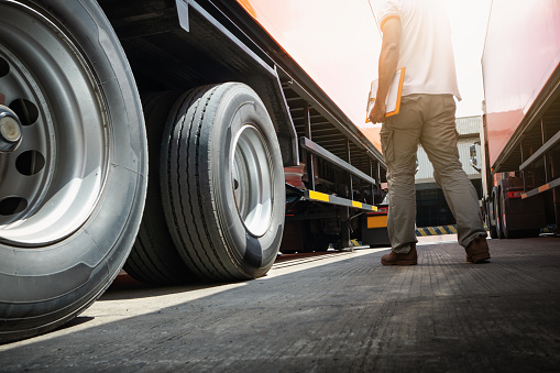 Trailer Truck on The Parking Lot. Truck Drivers Holding Clipboard Checking Wheels and Tires. Maintenance Checklist. Truck Inspection Safety Driving. Freight Truck Transport.