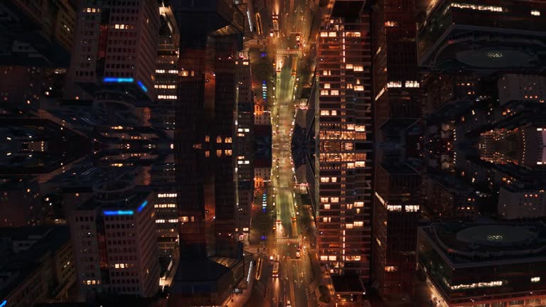 AERIAL Drone Shot of Illuminated Modern Skyscrapers and Urban Street at Night Abstract Mirror Effect
