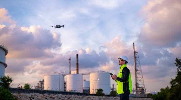 istock Engineer surveyor team under used drone camera for operator inspecting and survey construction site with gas oil refinery background 2047153835