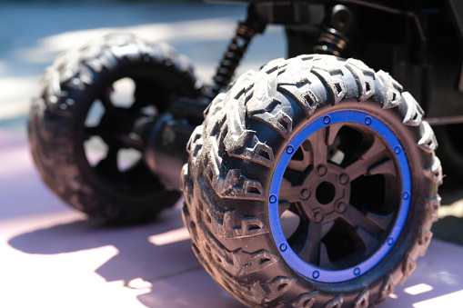 Toys Photography. Closeup Toys. Macro photo of RC (Remote Control) Car from the side view. There are lights, car wheels, suspension and bumpers. Shot with a macro lens