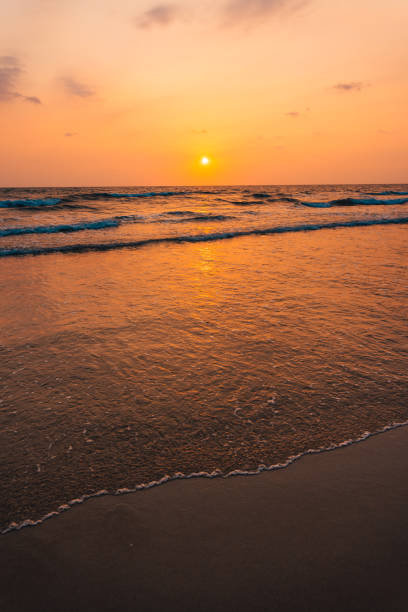 istock Sunset on the beach and orange sea waves 2047201083