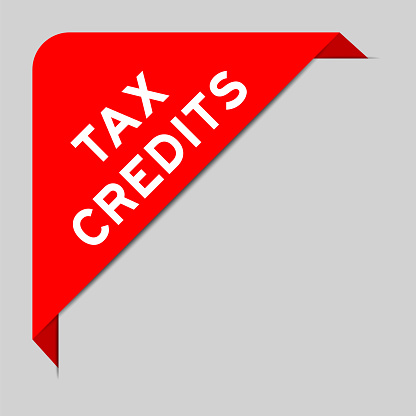 Red color of corner label banner with word tax credits on gray background