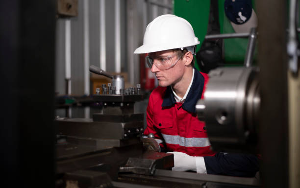 istock Industry engineer wearing safety uniform control operating lathe grinding machine working with detail tablet computer on hand in industry factory is metal manufacture industry concept. 2047207895
