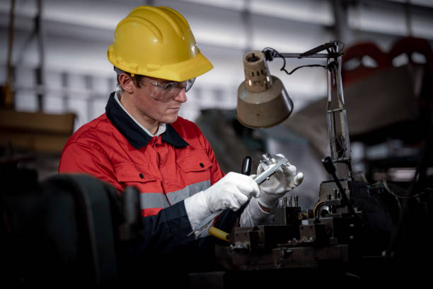 istock Industry engineer wearing safety uniform control operating lathe grinding machine working with detail tablet computer on hand in industry factory is metal manufacture industry concept. 2047208914