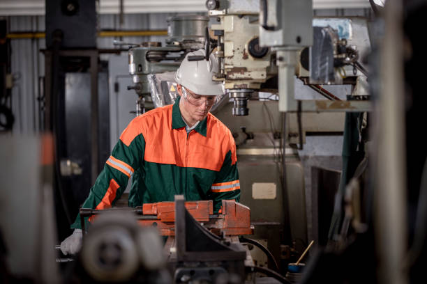 istock Industry engineer wearing safety uniform control operating lathe grinding machine working with detail tablet computer on hand in industry factory is metal manufacture industry concept. 2047210509