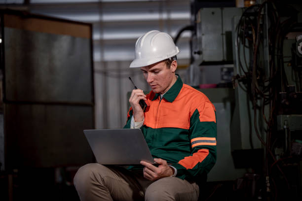 istock Industry engineer wearing safety uniform control operating lathe grinding machine working with detail tablet computer on hand in industry factory is metal manufacture industry concept. 2047211541