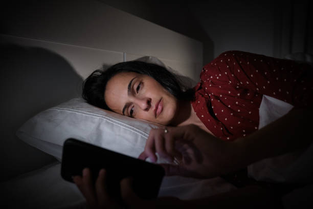 istock Hispanic woman surfing smartphone at night time 2047228223