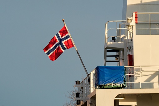 Norway flag on the stern of the ship. Norwegian ship in port.
