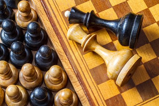 Vintage chess pieces. Wooden chessboard. Pawns and chess pieces.