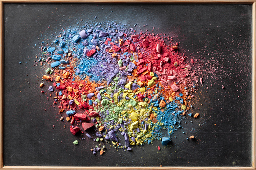 Multicolored chalk powder on a chalkboard.