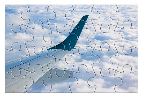 Airplane wing above the clouds in jigsaw puzzle shape - concept image which can mean: overcome fear of flying or solutions to air sickness or plan the trip by plane an so on