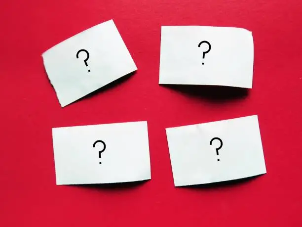 paper pieces with question mark on red background - SELF DOUBT concept, lack of confidence regarding yourself and your abilities