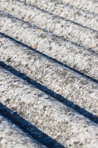 Old aged roof made of corrugated asbestos panels - dangerous materials in buildings and construction industry