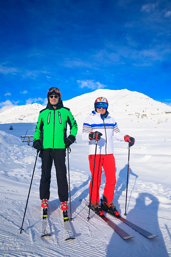 Skiing winter sport, Active lifestyle, two senior  men   best friends.  Snow skier, enjoying on sunny ski resorts.  Snowcapped mountain  Dolomite  ski area. Ski resort. italy, Europe.