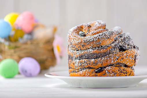 Pastry cruffins - cupcake-shaped croissants sprinkled with powdered sugar on a light wooden background, selective focus.