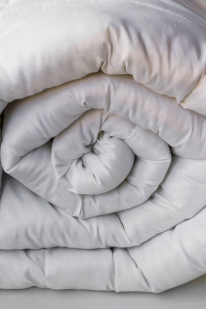 istock Soft,white,washable double size fiber quilt rolled-up on the white background 2047501660