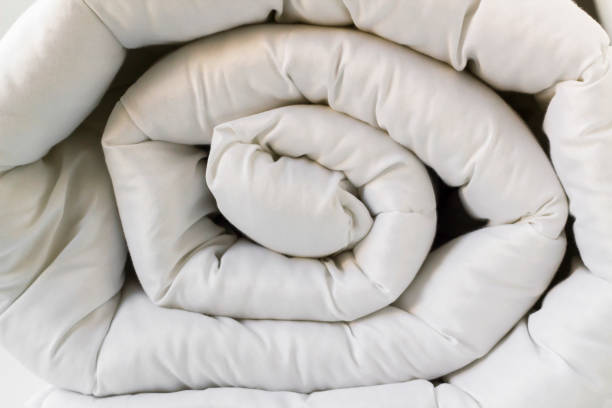 istock Soft,white,washable double size fiber quilt rolled-up on the white background 2047501684