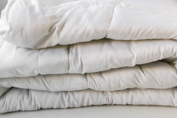 istock White color, folded clean double quilt on white surface 2047502719