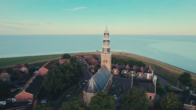A historic church in a coastal village at sunrise, tranquil and picturesque, aerial view