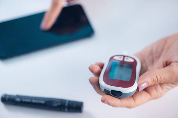 istock A person measures glucose levels, using a smartphone app for tracking and analyzing results, essential for diabetes management. 2047511282