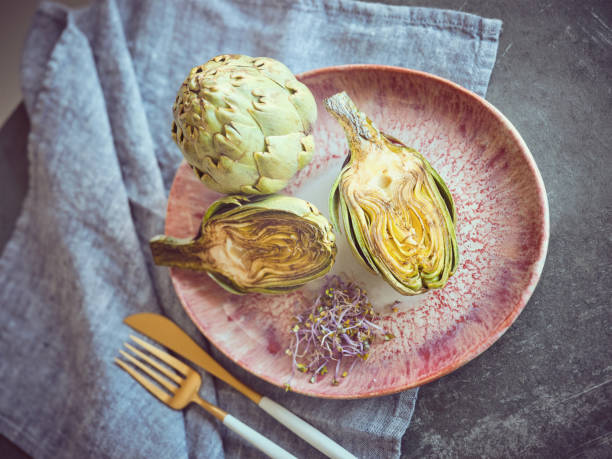 istock Cut artichokes with herbs on plate 2047516647