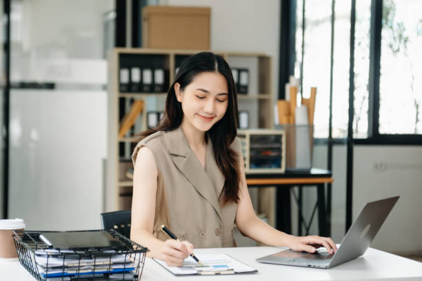 istock Young beautiful woman using laptop and tablet while sitting at her working place. Concentrated at work. 2047520956