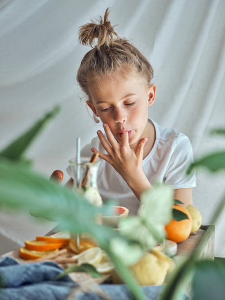 istock Boy licking finger at table with fruits 2047524221