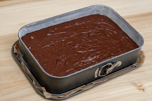 Raw brown brownie chocolate cake in a baking tin closeup