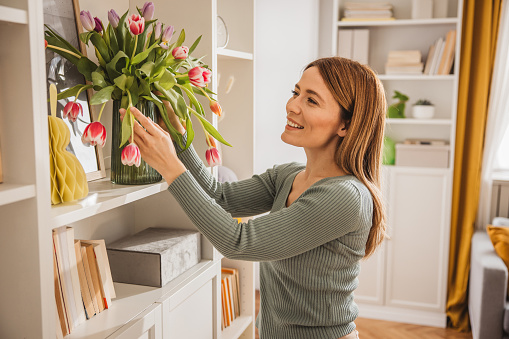 Young woman decorating apartment with Easter themed decor. Preparing for Easter.