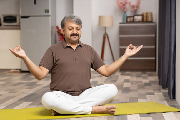 istock Mature man practicing yoga at home stock photo 2047634677