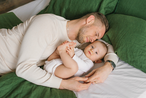 Father and son baby lying on the bed and enjoying the moment