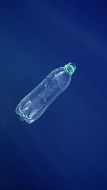 Discarded transparent plastic bottle slowly sinking into blue abyss of Mediterranean sea