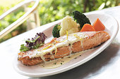 Grilled salmon fish steak with vegetables on restaurant table
