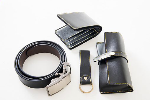 Men’s personal accessories isolated on white background. Sun glasses case, Wallet, Key chain, Leather belt.