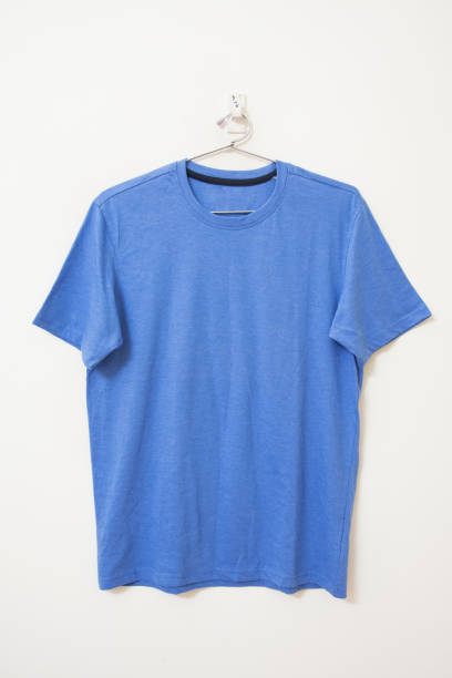 Front view of plain round neck blue t-shirt hanging on wall on isolated background