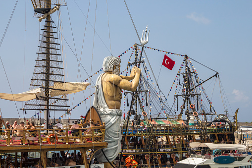 Turkey (Turkiye), Alanya, 09.09.2023: Masts of ships in the port of Alanya. Pirate ship with Poseidon holding a trident. Boat excursion in Turkey.