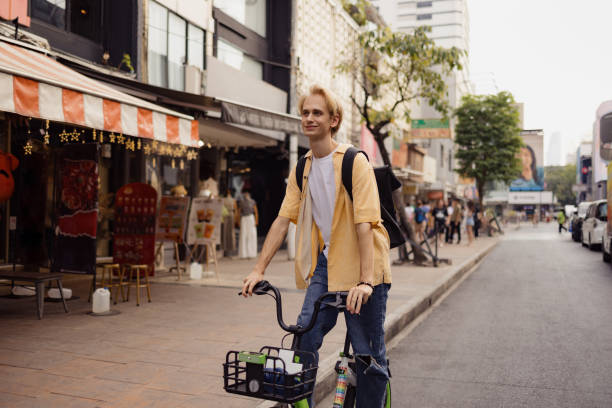 istock Smiling man having fun while cycling on the street. 2047731014