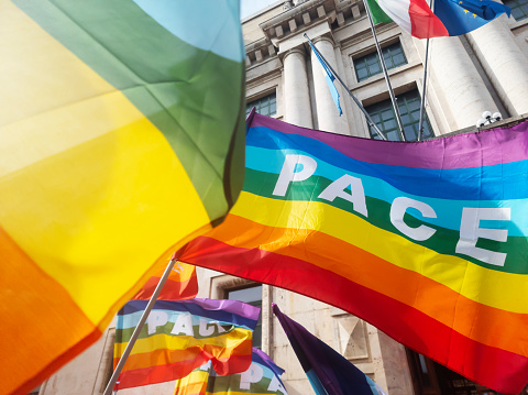 Pescara, February 25 2024: colorful rainbow flags flutter in the wind during a peace demostration that was held against the wars in Ukraine and Palestine, in front of a government building (the Prefecture) in Pescara. Also in the picture the flags of the Municipality, of Italy and of Europe