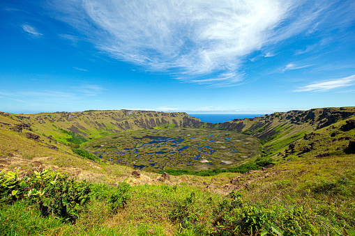 Rano Kau is a majestic crater located on Easter Island. Its vast expanse, formed by volcanic activity, is now home to a freshwater lake. Surrounding the crater are steep cliffs adorned with lush vegetation, creating a striking contrast against the rugged landscape. Rano Kau is not only a geological marvel but also holds cultural significance, with archaeological sites and petroglyphs found in its vicinity, offering insights into the island's rich history and heritage.