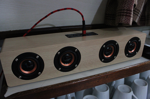 Close up of a wooden modern designed portable speaker sound system taken indoors