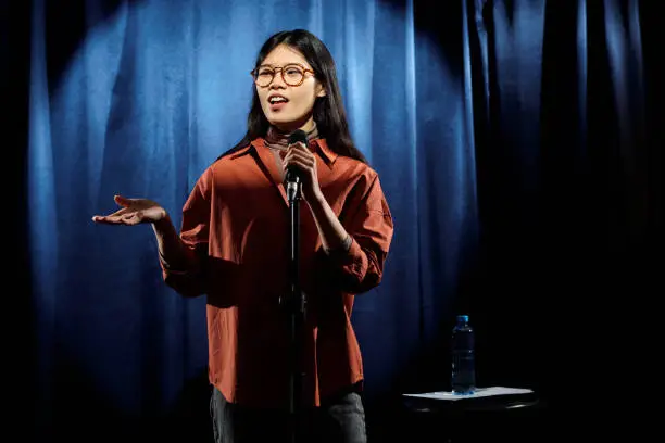 Photo of Comedian in eyeglasses and brown shirt