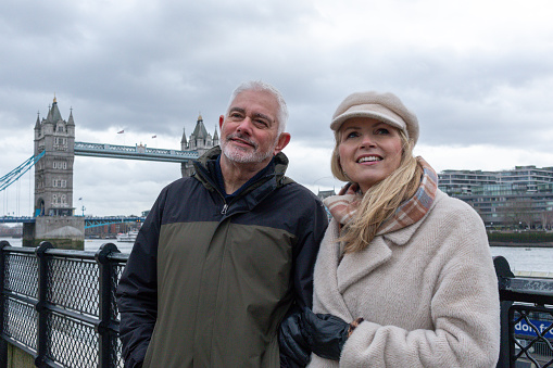 Senior couple talking with Tower Bridge, River Thames and the London skyline in the background