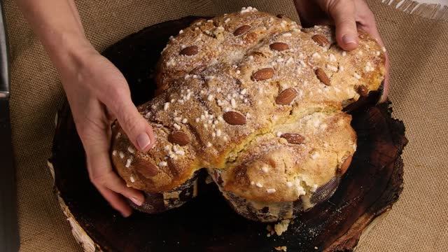 COLOMBA cake is a traditional Italian Easter dessert. The chef cuts the Easter colomba cake and demonstrates the delicate and airy pastry. Top view