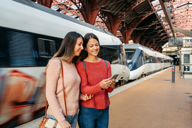 istock Two Female Friends Using A Phone While Waiting For A Train At The Railway Station In Copenhagen In Denmark 2047785629